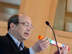 Neil Aronin utilizou blocos de Lego gigantes para explicar como é que as substâncias silenciadoras de genes podem dividir-se em moléculas mais pequenas, com efeitos colaterais próprios. Crédito da Imagem: Lev Blumenstein, para a "CHDI"